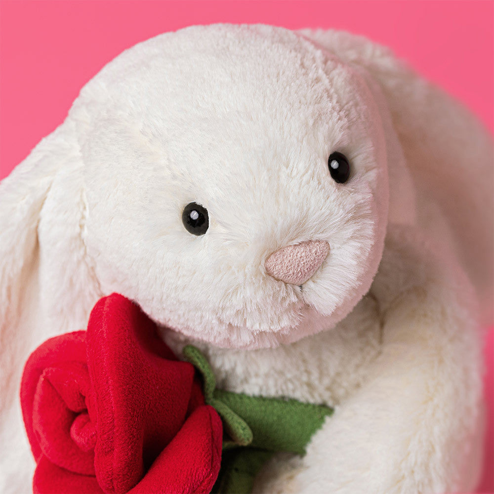 Peluche Jellycat lapin Bashful crème avec rose sur lit – Jellycat Bashful cream bunny with rose plush on bed – Olie & co