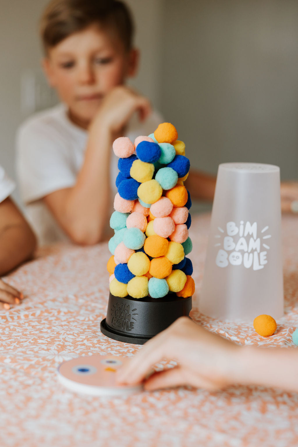 Enfant retirant une boule du jeu d’adresse Bim Bam Boule Loki – child removing a ball from Loki Bim Bam Boule skill game – Olie & co