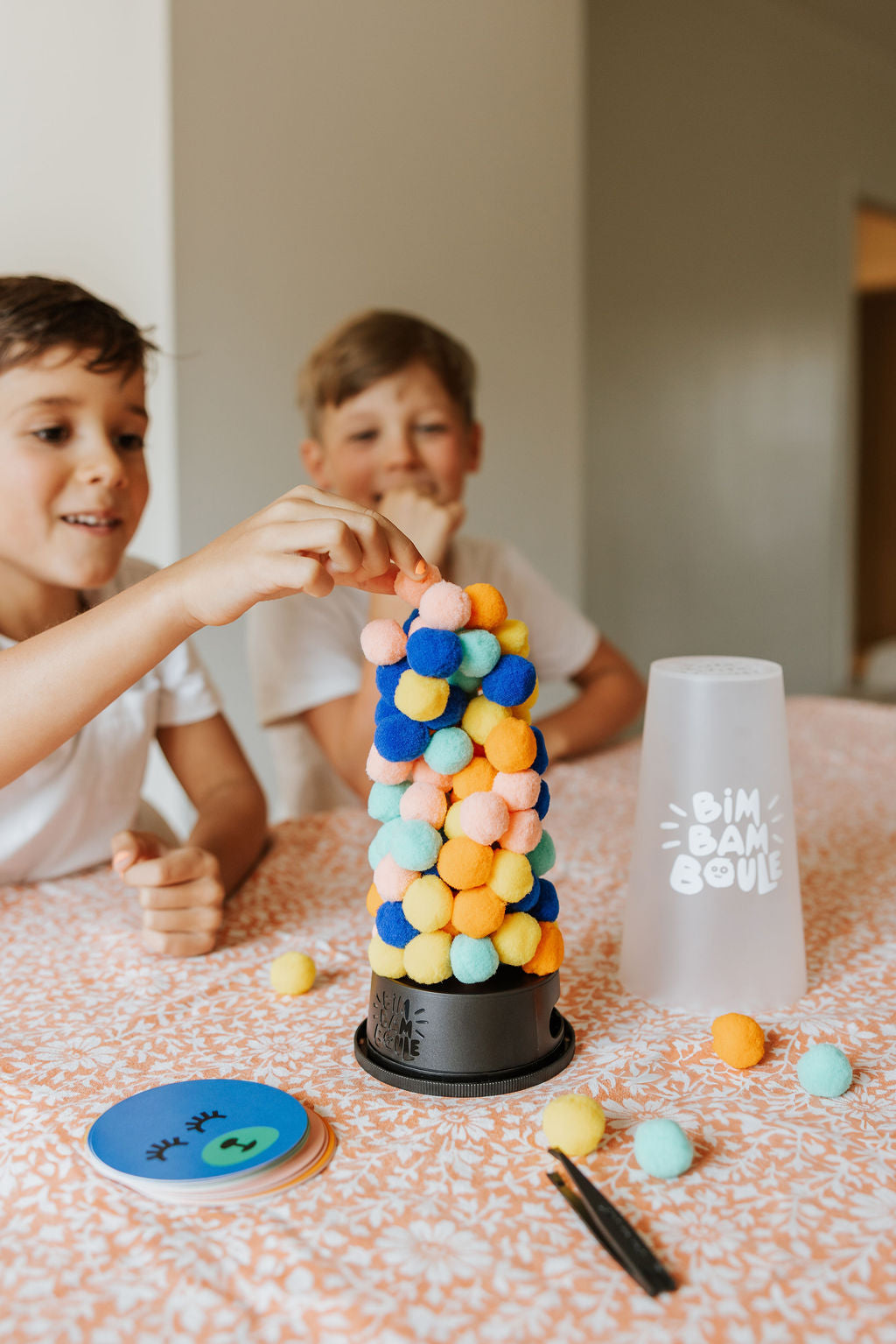 Enfant retirant une boule du jeu d’adresse Bim Bam Boule Loki – child removing a ball from Loki Bim Bam Boule skill game – Olie & co