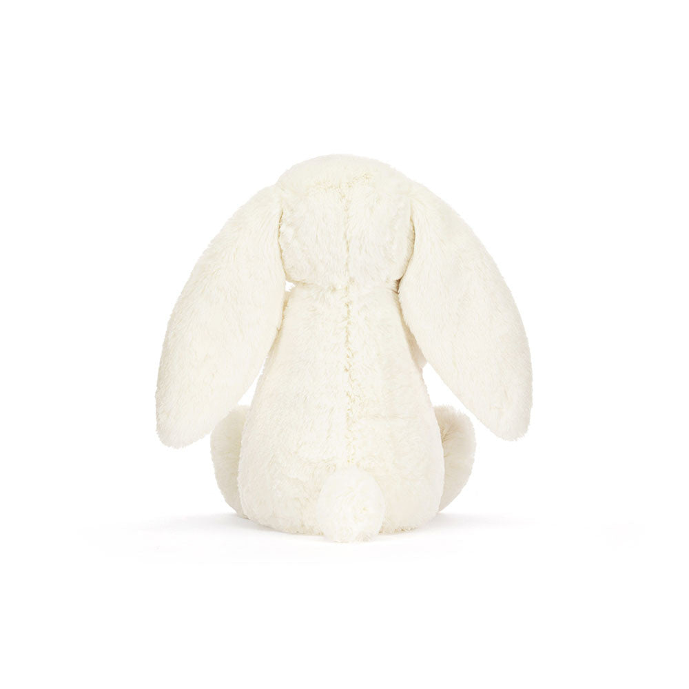 Peluche Jellycat lapin Bashful crème avec rose sur lit – Jellycat Bashful cream bunny with rose plush on bed – Olie & co