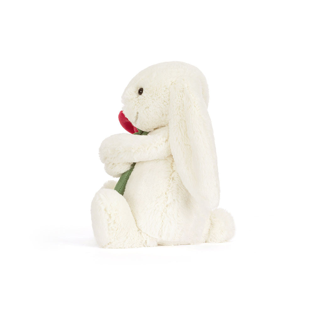 Peluche Jellycat lapin Bashful crème avec rose sur lit – Jellycat Bashful cream bunny with rose plush on bed – Olie & co