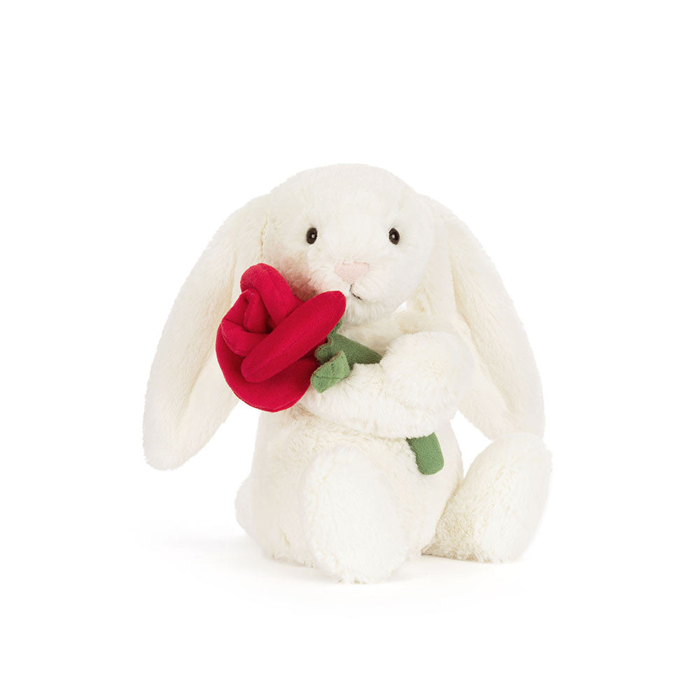 Peluche Jellycat lapin Bashful crème avec rose sur lit – Jellycat Bashful cream bunny with rose plush on bed – Olie & co