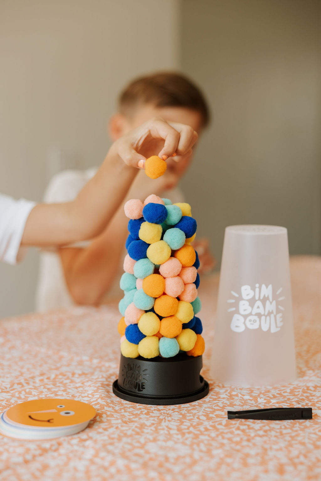 Enfant retirant une boule du jeu d’adresse Bim Bam Boule Loki – child removing a ball from Loki Bim Bam Boule skill game – Olie & co